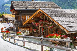 Old wooden houses with flower boxes in front of the windows and on the wooden fence, historic