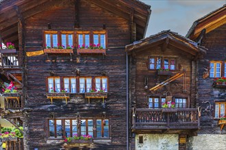 Old wooden houses with flower boxes in front of windows and balconies, historic village centre,