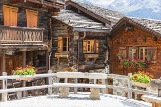 Bench in front of old wooden houses in the historic village centre, Grimentz, Val d'Anniviers,