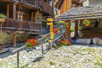 Hiking trail with signposts leads through the historic village centre, Grimentz, Val d'Anniviers,