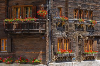 Old wooden houses with flower boxes in front of the windows in the historic village centre,