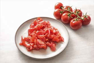 Tomatoes, whole and chopped on a plate, ingredient for various dishes, healthy cooking concept,