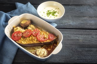 Baked half eggplant and stuffed mushrooms with garlic, ginger, onions and tomatoes in a casserole,