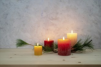 Four candles lit for the fourth Advent, pine branch as a simple, minimal decoration on a light