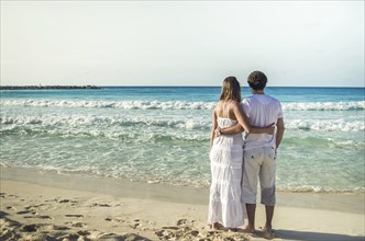 Couple of lovers on their backs, looking at the caribbean sea