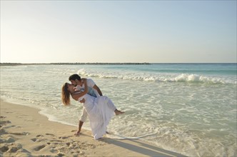 Couple of lovers kissing on the beach shore of the Caribbean