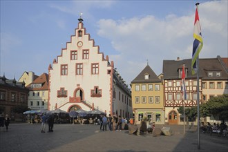 Historic town hall with stepped gable on the market square, flags, people, Karlstadt, Bavaria,