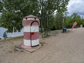 Old round red-white-ringed changing room from GDR times in the shape of a lighthouse on the shore