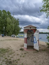 Old round red-white-ringed changing room from GDR times in the shape of a lighthouse on the shore