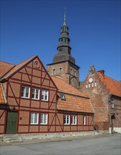 Old half-timbered building from the 18th century with St. Mary's Church from the 13th century in