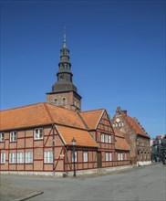 Old half-timbered building from the 18th century with St. Mary's Church from the 13th century in