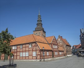 Old half-timbered building from the 18th century with St. Mary's Church from the 13th century in