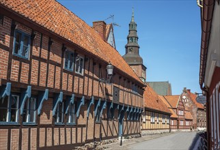 Old half-timbered building from the 18th century with St. Mary's Church from the 13th century in