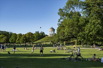 People playing volleyball in a meadow in the English Garden, people enjoying the summer day in the