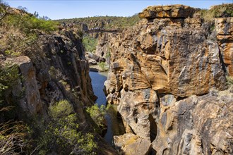 Bridge over a canyon with steep orange-coloured cliffs and the Blyde River, Bourke's Luck Potholes,