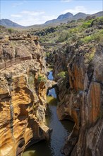 Bridge over a canyon with steep orange-coloured cliffs and the Blyde River, Bourke's Luck Potholes,