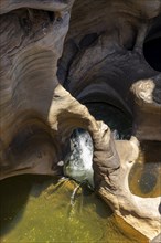 Water flowing through eroded rock formations, canyon with steep orange-coloured rock cliffs with