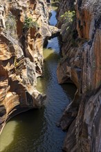 Eroded rock formations, canyon with steep orange-coloured rock cliffs with the Blyde River,