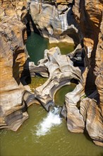 Eroded rock formations, canyon with steep orange-coloured rock cliffs with the Blyde River,