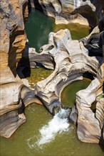 Eroded rock formations, canyon with steep orange-coloured rock cliffs with the Blyde River,