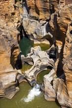 Eroded rock formations, canyon with steep orange-coloured rock cliffs with the Blyde River,