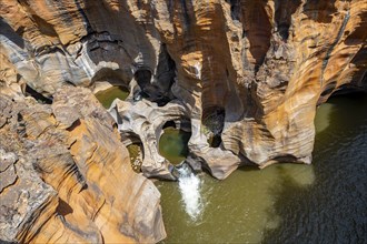 Eroded rock formations, canyon with steep orange-coloured rock cliffs with the Blyde River,