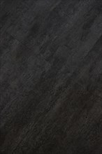 Vertical image of the texture of a dark gray and black tile, AI generated