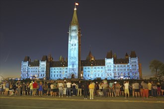 Night event with people in front of an illuminated historical building, laser show in front of the