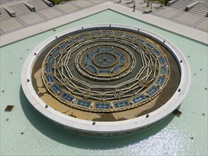 Circular fountain with complex geometric design, embedded in an extensive water landscape in a