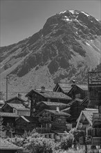 Nested old wooden houses, in the background the summit of the mountain Scex de Marenda, historic