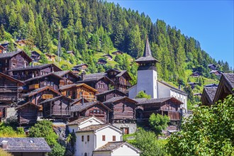 Old wooden houses in the historic centre of Grimentz, with the church of Saint Theodule, Val