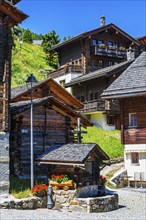 Old wooden houses with wooden shingle roofs and flower boxes in the historic centre of Grimentz,