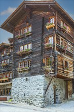 Old wooden house with flower boxes in front of the windows, historic village centre, Grimentz, Val