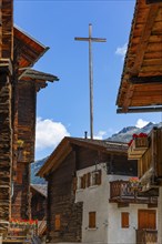 Large wooden cross above old houses in the historic village centre, Grimentz, Val d'Anniviers,