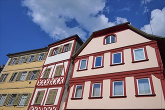 Three colourful half-timbered houses stand under a blue, cloudy sky, Karlstadt, Main Spessart,