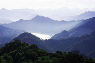 A misty mountain range with layered hills and valleys bathed in tranquil morning light, Shimen