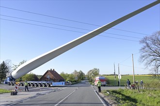 Heavy duty transport of a windmill blade lifted up to avoid obstacles such as a power lines on a