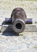 Cast iron cannon at the Holstentor or Holsten gate, historic landmark and tourist attraction in the