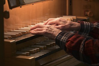 Old Hands of an organist playing on the organ keyboard also called manual, traditional musical