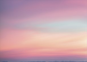 Calm gradient sky with pastel pink and blue colors above distant hills, AI generated