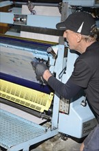 GREYMOUTH, NEW ZEALAND, MAY 22, 2015: An unidentified printer removes the plates after printing a