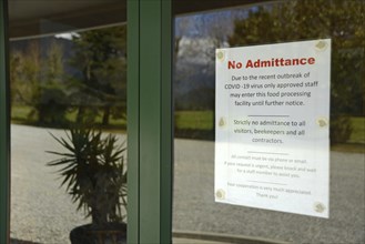 Signage shows that an essential food processing business has restricted access during the Covid 19