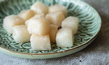 Korean honey rice cakes (yakgwa) on a pastel green plate AI generated