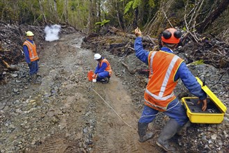 Men setting off explosive charges in a seismic reflective survey looking for oil on the West Coast