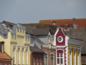 Row of colourful historic buildings with different roof shapes and windows in sunny weather, husum,