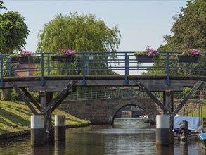 Wooden bridge over a canal, decorated with flower boxes, sunny day, friedrichstadt,