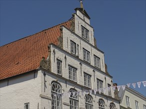 Historic building with red roof and white walls under a clear blue sky, friedrichstadt,