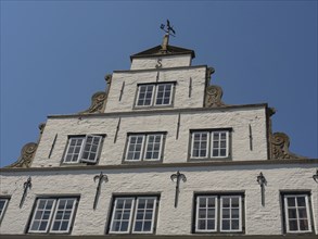 Historic house facade with many windows and decorative elements under a blue sky, friedrichstadt,