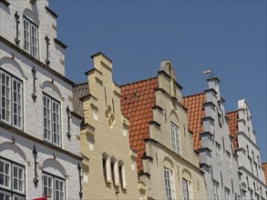 Historic half-timbered houses with characteristic gables and brick facades under a blue sky,