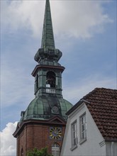 Historic church tower with green roof and clock next to a building, Arnis, Schleswig-Holstein,